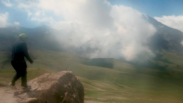 Mode de vie. concept de survie. touriste assis sur la pierre. Et des vagues dans la distance. En randonnée. Foggy, jour de pluie, vue arrière. rochers, montagnes. sport. — Video