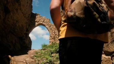 Turist antik şehrin kalıntıları arasında yürüyor. Eski geçitten geçer. Seyahat yaşam tarzı. Yaşam tarzı konsepti. Tatil, tatil, tatil. Dağıstan. Aul Gamsutl!
