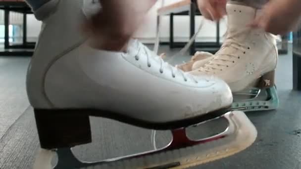 Women put on skates. Close-up. Weekend at the rink. Winter sports. Blade.Lacing. Preparation before going on the ice. Active lifestyle concept. shoes, legs. — Stockvideo