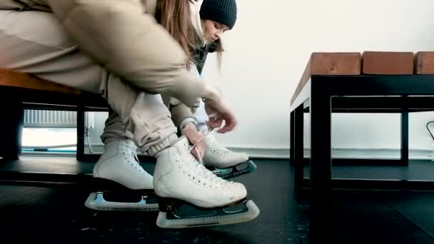 Women put on skates. Close-up. Weekend at the rink. Winter sports. Blade.Lacing. Preparation before going on the ice. Active lifestyle concept. shoes, legs. — Stockvideo