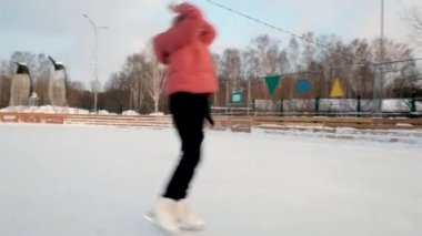 Dişi buz patenci paten sahasında bir element sergiliyor. Yakın plan. - Güneşli bir hafta sonu. Kış sporları. Aktif yaşam tarzı konsepti. Kadın. Eğitim, hız, virtüözlük, meslek