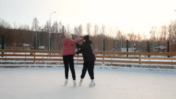 Two female figure skaters perform an element at the rink. close-up. Sunny weekend. Winter sports. Active lifestyle concept. female. Training, speed, virtuosity, professional — Stock videók