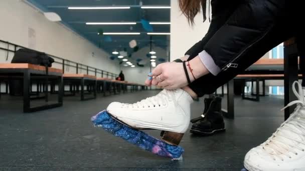 Women put on skates. Close-up. Weekend at the rink. Winter sports. Blade.Lacing. Preparation before going on the ice. Active lifestyle concept. shoes, legs. — Stockvideo