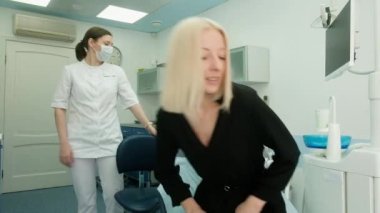 Kadın dişçi muayenehanede hastayla tanışır. Bir kadın müşteri rutin bir muayene için dişçi kliniğine geldi. Diş bakımı ve tedavi. Protez, taç..