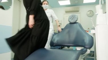 Kadın dişçi muayenehanede hastayla tanışır. Bir kadın müşteri rutin bir muayene için dişçi kliniğine geldi. Diş bakımı ve tedavi. Protez, taç..