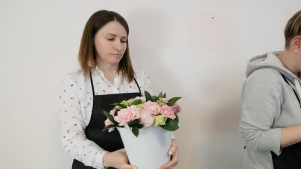 Blommor kvinna gör blommig design. Praktiken att göra vackra blombuketter av unga yrkesverksamma. Jobbar i en blomsteraffär. förberedelse för semester, bröllop, årsdag — Stockvideo