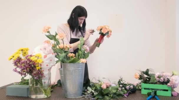Kwiaciarnia tworzy kwiatowe wzory. Praktyka tworzenia pięknych bukietów kwiatów przez młodych profesjonalistów. Praca w kwiaciarni. przygotowanie do urlopu, ślubu, rocznicy — Wideo stockowe