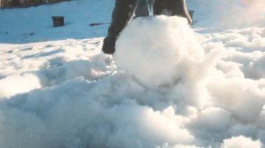 Yakın plan. Kartopu yuvarlıyorum. Kartopu oynamak ve şehirde kar atmak güneşli bir kış gününde dışarıda eğlenmek. Hafta sonu, yürüyüş, park