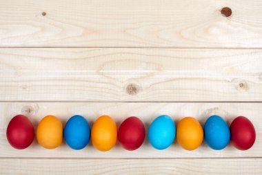 Renkli Paskalya yumurta dekorasyon çizgi boşaltmak Festival arka plan kompozisyon olarak hafif ahşap yüzey üzerinde