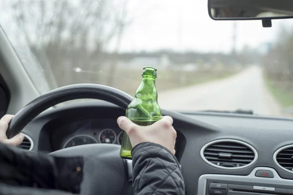 Joven conduciendo su coche mientras bebe alcohol —  Fotos de Stock