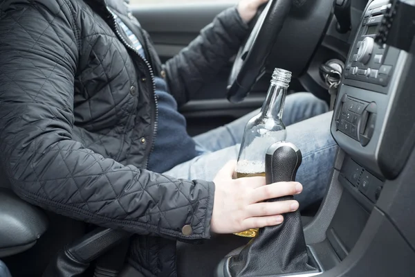 Giovane uomo che guida la sua auto mentre beve alcol — Foto Stock