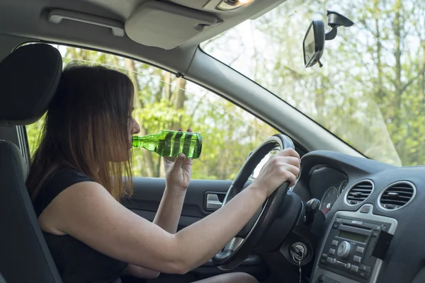 Kvinna dricker alkohol i bilen. — Stockfoto