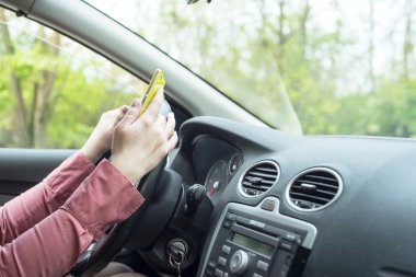 kadın arabada bir akıllı telefon ile