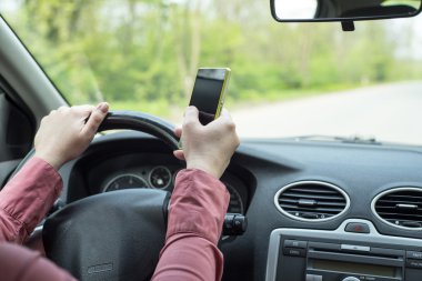 kadın arabada bir akıllı telefon ile