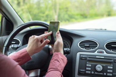 kadın arabada bir akıllı telefon ile