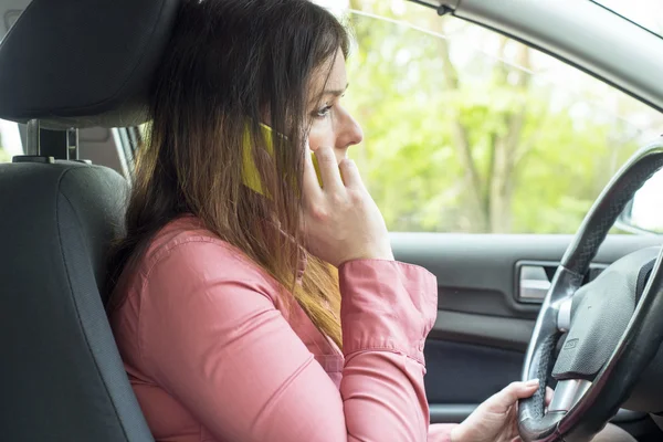 Vrouw met een smartphone in de auto — Stockfoto