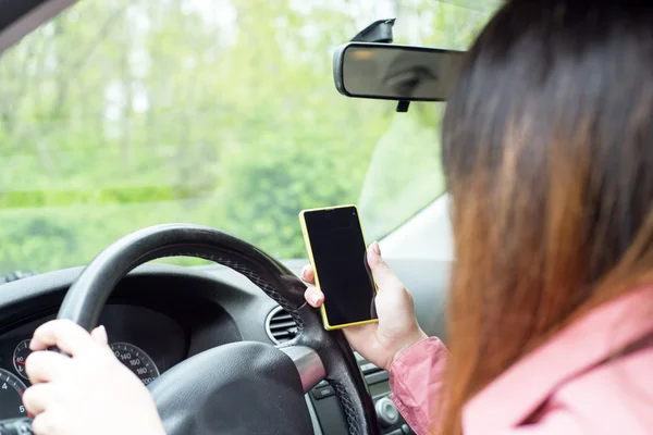 Kvinna med en smartphone i bilen — Stockfoto