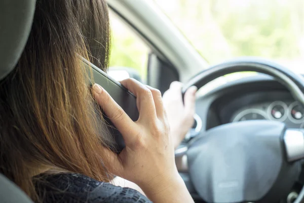 Kvinna med en smartphone i bilen — Stockfoto