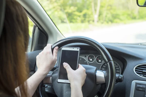 Donna con uno smartphone in macchina — Foto Stock