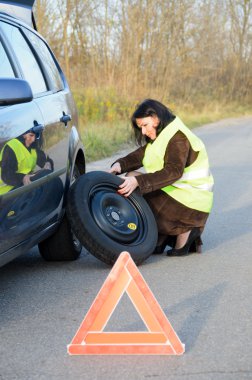 Kadın arabada tekerlekli değiştirme