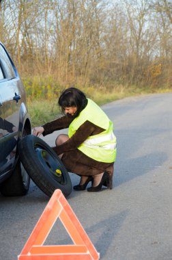 Kadın arabada tekerlekli değiştirme