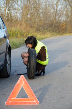 Kadın arabada tekerlekli değiştirme