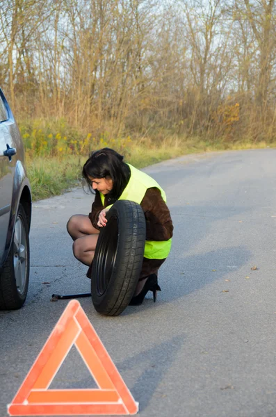 Woman changing the wheel in the car — Stock Photo, Image