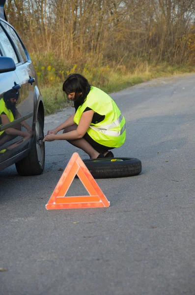 Kadın arabada tekerlekli değiştirme