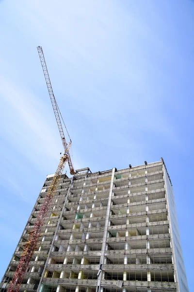 Demolição de um arranha-céu com um guindaste alto — Fotografia de Stock