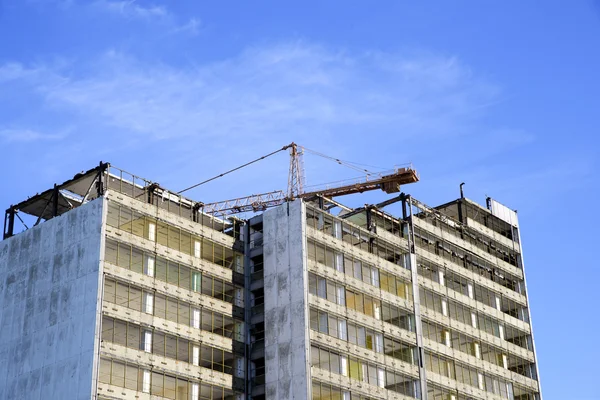 Demolición de un rascacielos con una grúa alta — Foto de Stock