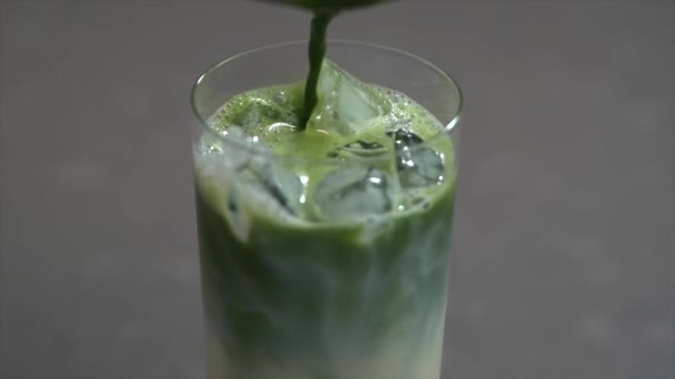 Matcha vert glacé avec du lait dans un verre. Thé vert Matcha. Produit biologique. Matcha en poudre. — Video