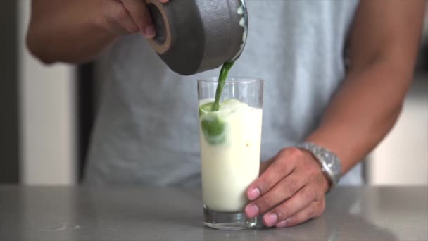 Matcha groene thee. Biologisch product. Matcha poeder. IJsgroene matcha met melk in een glas. — Stockvideo