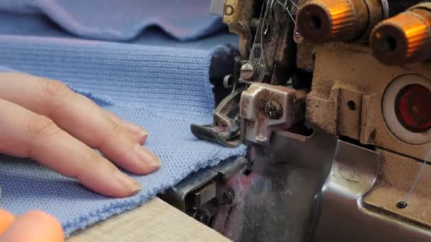 Overlock máquina de costura. Mãos femininas a trabalhar no Tailoring. Máquina de costura têxtil industrial automatizada. Produção de vestuário de malha. — Vídeo de Stock