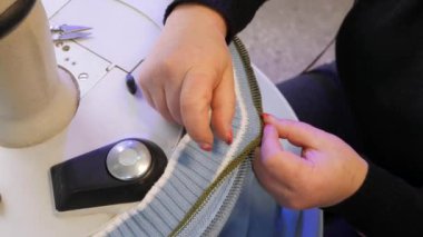 Kıyafet Yapımı. Terzilikte çalışan kadın eller. Kumaş fabrikası. Endüstriyel Tekstil dikiş makinesi. Örgü kumaş üretimi.