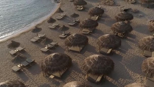 Playa vacía con sombrillas por la mañana, vista aérea. — Vídeo de stock