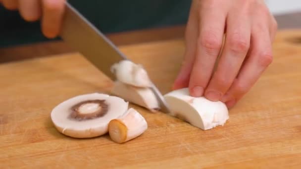 木製のまな板にナイフでキノコを切断女性の手。野菜を切る。アガリクス・カンペストリス、アガリクス・ビスポラス. — ストック動画