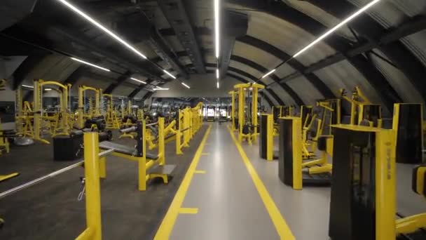 Empty modern gym interior with sports equipment, heavy gym equipment arranged inside modern fitness club. — Stock Video