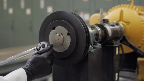 Estación de servicio de turismos. Mecánico, cerrajero trabajador apretando las tuercas en el motor del coche con destornillador. Tuerca atornilladora en unidad industrial con llave dinamométrica en bloque. Montaje manual de grandes — Vídeo de stock