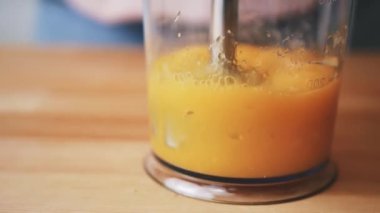 Bebek maması. Blender 'da yemek hazırlıyor. Meyve püresi karıştırıcıda yapılıyor. Mangolar bir karışıma, meyve püresine, evde tek başına sağlıklı yiyeceğe, diyete ve ham ürünlere gömülür.