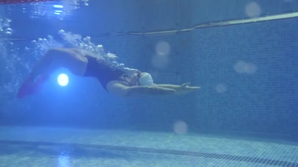Αθλητισμός και αντοχή. Επαγγελματίας κολυμβητής κολυμπά ανάποδα σε μια πισίνα. Τεχνική ύπτιο. — Αρχείο Βίντεο
