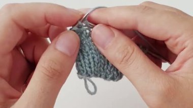 Yakından örgü örüyorum. Örgü iğneleri. Örgü ören kadın elleri. El işi hobisi..