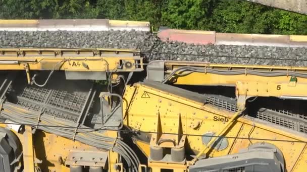 Budowa dróg. Zakłady asfaltu i betonu. kruszarka z gruzem. Taśma transportowa ze żwirem. Przenośnik porusza gruzami. — Wideo stockowe