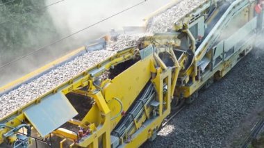 Çakıl taşlı taşıma bandı. Yolların inşaatı. Asfalt-beton fabrikası. Molozla ezici. Taşıyıcı molozları hareket ettirir.
