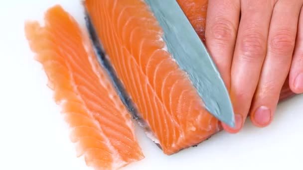 Chef macho corta, rebanando un filete de salmón fresco en el bar de sushi, restaurante. Corte de cuchillo afilado. Cocinar pescado en la cocina. Ingredientes alimentarios para gourmets. Cocina japonesa. — Vídeo de stock