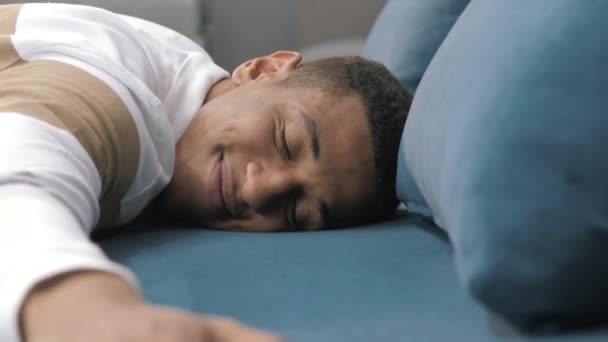 Guy lays down onto the sofa. Attractive, charismatic guy. Rest, day off. Difficult work week — Stock Video