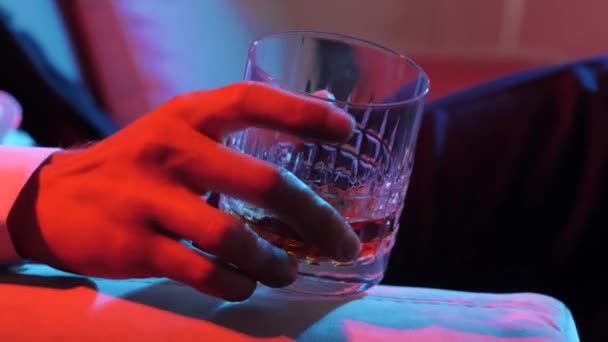Whisky de lujo. Empresario sosteniendo whisky en un vaso. Bourbon en Highball. El hombre remover lentamente whisky dorado en el vaso en la mano. — Vídeos de Stock