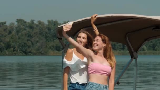 Les jeunes se détendent sur un yacht. Fête sur un yacht. Promenade sur un yacht le long de la rivière. Croisière sur un bateau. Belles amies prennent un selfie. — Video