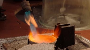 Yakıt feneriyle mücevher için altın eritme işlemi. Altınla çalışan kuyumcular yakıcı ateşle erir. Profesyonel aletlerle mücevher yapımı..