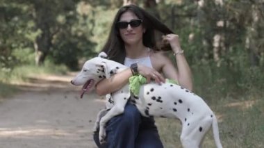 Kız ve Dalmaçyalı bir köpek. Köpekle oynamak, evcil hayvanla neşeli yürüyüş. Köpekle yürü..