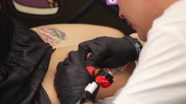 Τατουάζ στο σώμα. Καλλιτέχνης τατουάζ κάνει τατουάζ στο studio — Αρχείο Βίντεο